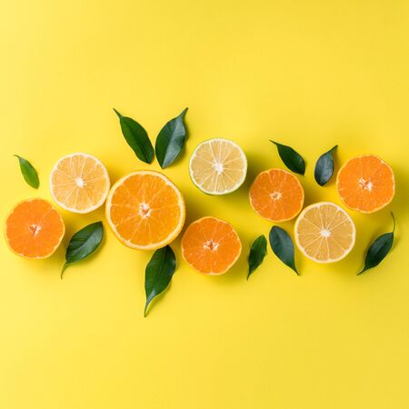 Creative background with tropical fruits. Orange, lemon, lime, grapefruit on a yellow background. Flat lay top view copy space. Nutrition Concept, Vitamin C, Disease Prevention, Fluの写真素材