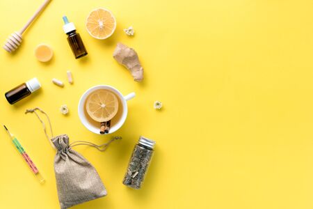 Illness concept. Composition alternative medicine. Herbal tea, ginger and lemon on a yellow background. Flat lay. View from above. Copy spaceの写真素材