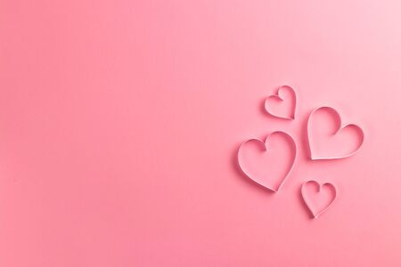 Composition for Valentines Day February 14th. Delicate pink background and pink hearts cut out of paper. Greeting card. Flat lay, top view, copy space.の写真素材