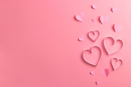 Composition for Valentines Day February 14th. Delicate pink background and pink hearts cut out of paper. Greeting card. Flat lay, top view, copy space.の写真素材