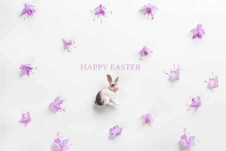 Happy easter card. Stylish minimalistic composition on a white background. Figurine of a rabbit and...