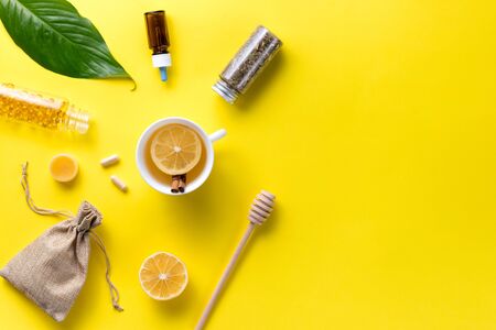 Illness concept. Composition alternative medicine. Herbal tea, ginger and lemon on a yellow background. Childs health. Flat lay. View from above. Copy spaceの写真素材