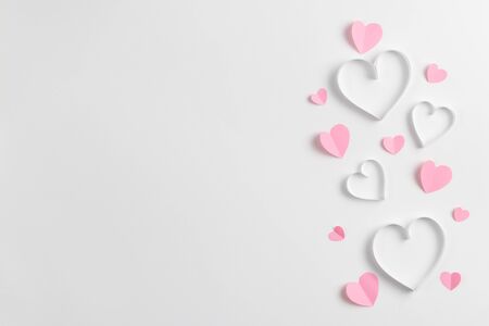 Composition for Valentine's Day February 14th. Delicate composition of pink hearts made of paper on a white background. Heart cut out of paper. Greeting card. Flat lay, top view, copy spaceの写真素材
