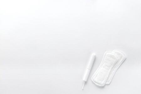 Tampons, feminine sanitary pads on a white background. Hygienic care on critical days. menstrual cycle. Caring for women's health. Monthly protection. Flat lay, top view, copy space.の写真素材