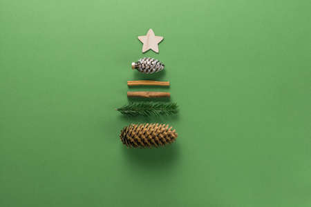 Christmas composition. Creative christmas background. Christmas decorations and gifts in the form of a Christmas tree against a green background. Flat lay, top view, copy space.の写真素材