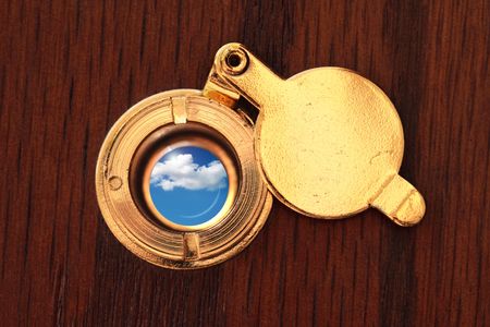 Peephole to the better world. Close up of door viewer and cloudy skyの写真素材