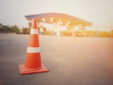 Red rubber cone on concrete floor in gas station, blurred background imageの写真素材