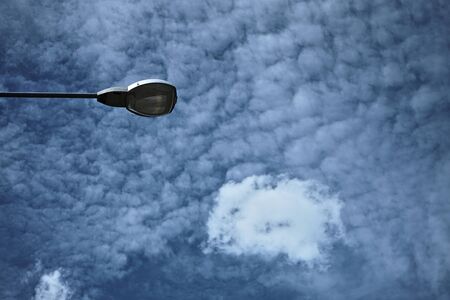 Electric light during the day, with a backdrop of cloudsの写真素材