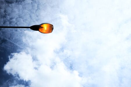 Electric light during the day, with a backdrop of cloudsの写真素材