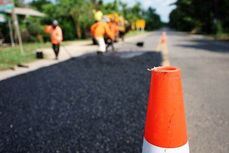Repairing a damaged road By adjusting the level with asphalt mixed with small stones And then compacted with a vibratory compactorの写真素材