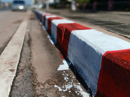 The edge of the pavement is painted white-red. Cars are not allowed to park in this area.の写真素材