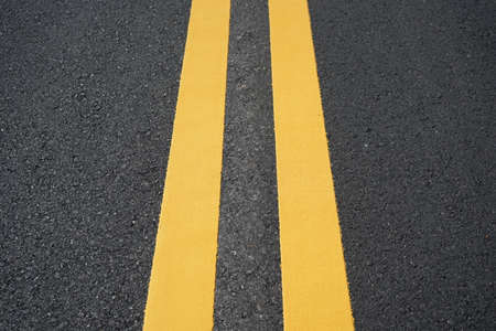 Blurred image, yellow traffic line on paved road