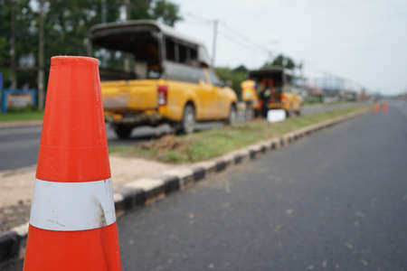 Red rubber cone and blurry background image working on the road.