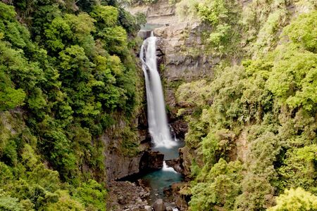 a cascade falling down into lake in taiwanの写真素材