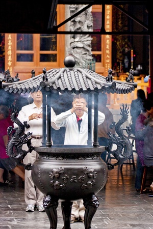 Taipei-May 24:a group of prayer in front of a censer in chinese temple on May 24,2011 in Taiwanのeditorial素材
