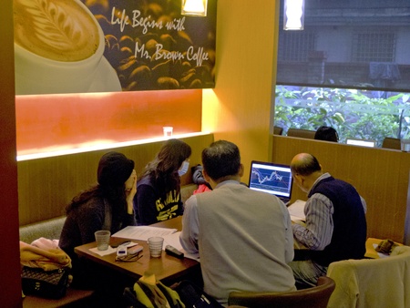 Taipei-January 23:a group of people concentrate on stock information in a coffee shop on January 23,2011 in Taiwanのeditorial素材