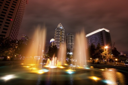 broad view of skyscraper modern building with fountains at night