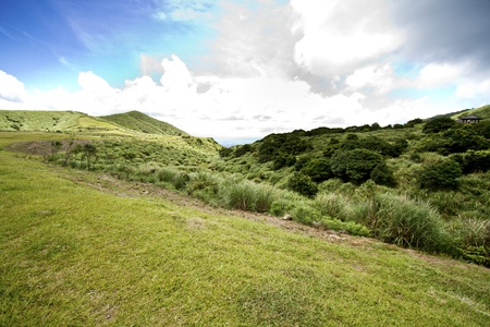 Grass Mountain and blue cloudy sky background located in Taipei, Taiwanの写真素材