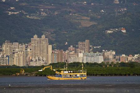 view of a travelling ship running on river against cityscapeの写真素材