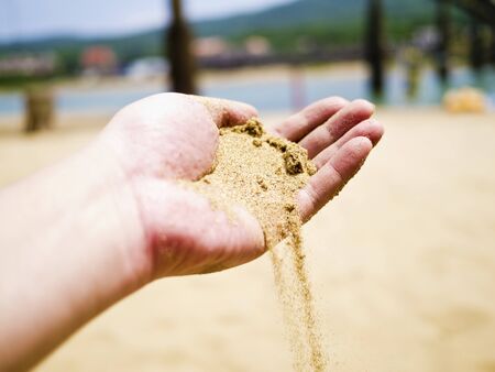 beach sands dropping from handの写真素材