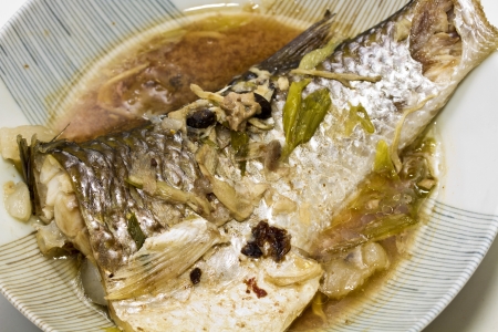 Fish in soy sauce, served on white plate