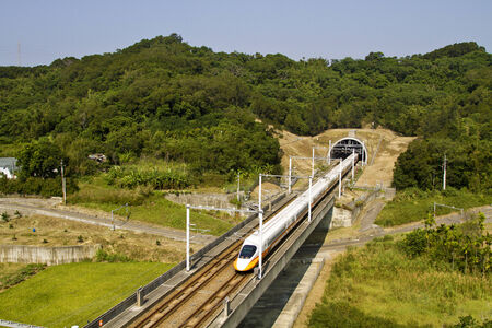 high speed train driving across tunnel with mountain sceneryのeditorial素材
