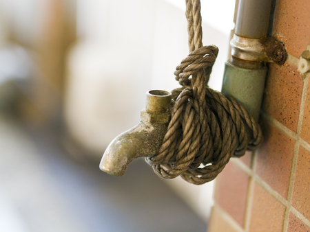old brass faucet with rope tie on