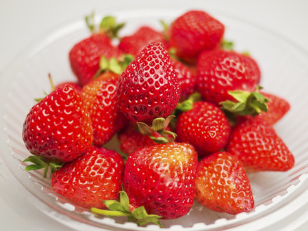 Fresh strawberries were placed in plate on a white backgroundの写真素材