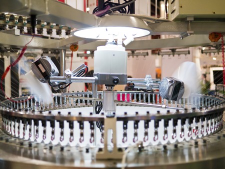 Textile industry - yarn spools on spinning machine in a textile factoryの写真素材