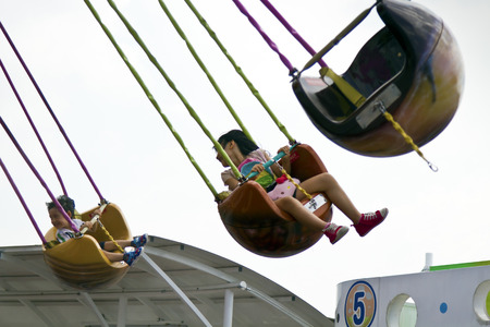 Taipei, Taiwan - SEP 30 ,2015: happy young children on the chain swing carousel  in The Taipei...