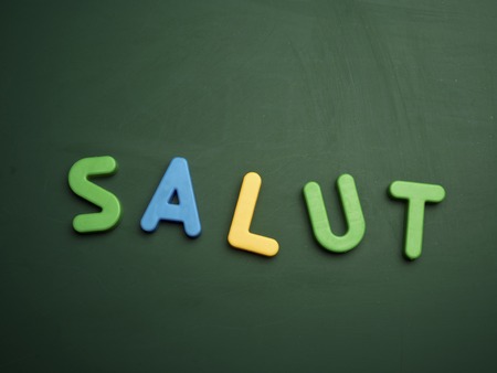 salut concept in colorful letters isolated on blank blackboardの写真素材