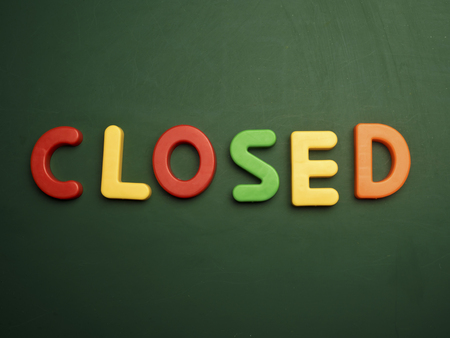closed concept in colorful letters isolated on blank blackboardの写真素材