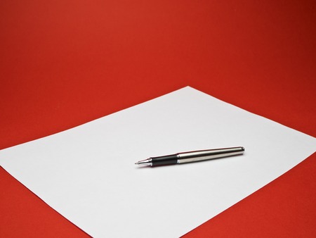 ball point silver pen on white paper with red backgroundの写真素材