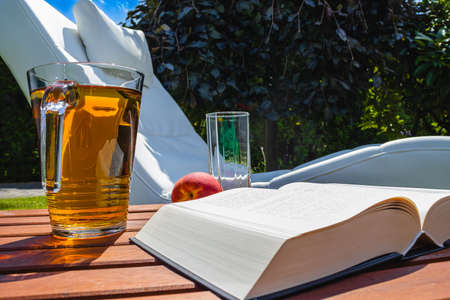 Relax with a book, sweet peach and apple juice in the fresh air.