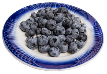 Fresh blueberries on blue plate. Isolated image.の写真素材