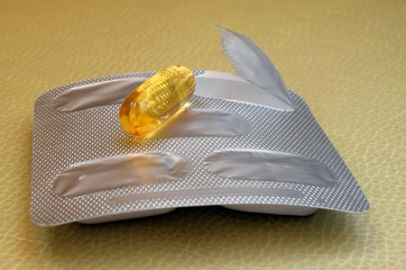 Yellow transparent tablet fish oil and packagingの写真素材