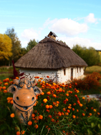 Wooden log old Ukrainian house - landscape and a clay cow. Kiev, Kyiv, Ukraineの写真素材
