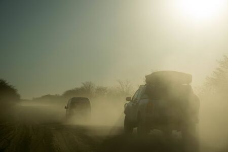 Safari car moving fast in the dust, looking for wild animals in Africa, Botswana, Namibiaの写真素材