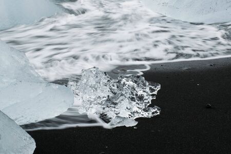 Little Iceberg on the black beach of diamond Beach Iceland. White and clear ice on the black beach...