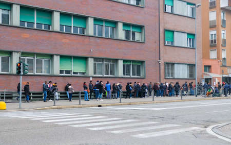 Italy, Como, March, migrants lined up in front of the police office to receive a residence permit or asylumのeditorial素材