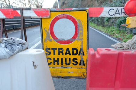 road construction site with a yellow sign indicates the road closed for renovation