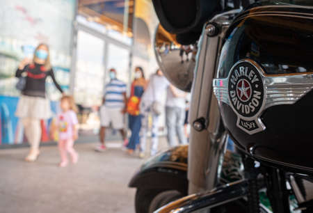 Italy, Milan, 05/31/2020, people walk wearing surgical mask due to the social distance for coronavirus covid-19. On the right a harley davidson motorcycleのeditorial素材