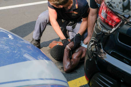 Italy, Como, 09/14/2020, Italian police arrest black man after scuffle. Thrown to the ground immobilized with handcuffs, the man had attacked his wifeのeditorial素材
