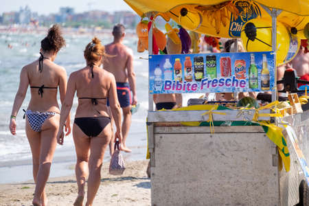 Italy, Chioggia, 06/25/2020. Beach mobile drink vendor cart with fresh fruit juces and shakes. in the background tourists in swimsuitsのeditorial素材