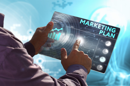 Business, Technology, Internet and network concept. Young business man, working on the tablet of the future, select on the virtual display: marketing planの写真素材