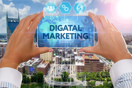 The girl looks at a virtual screen of Smartphone and see the inscription : Digital Marketingの写真素材