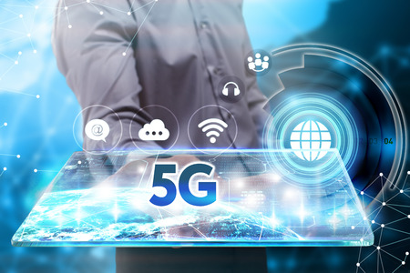Business, Technology, Internet and network concept. Young businessman working on a tablet of the future, he sees the inscription: 5Gの写真素材