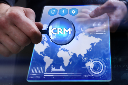 Business, Technology, Internet and network concept. Young businessman showing a word in a virtual tablet of the future: CRMの写真素材