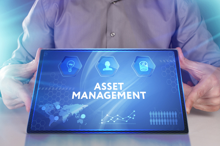 Business, Technology, Internet and network concept. Young businessman working on a virtual screen of the future and sees the inscription: Asset managementの写真素材