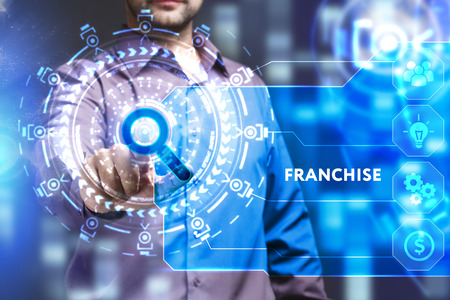 Business, Technology, Internet and network concept. Young businessman working on a virtual screen of the future and sees the inscription: Franchiseの写真素材